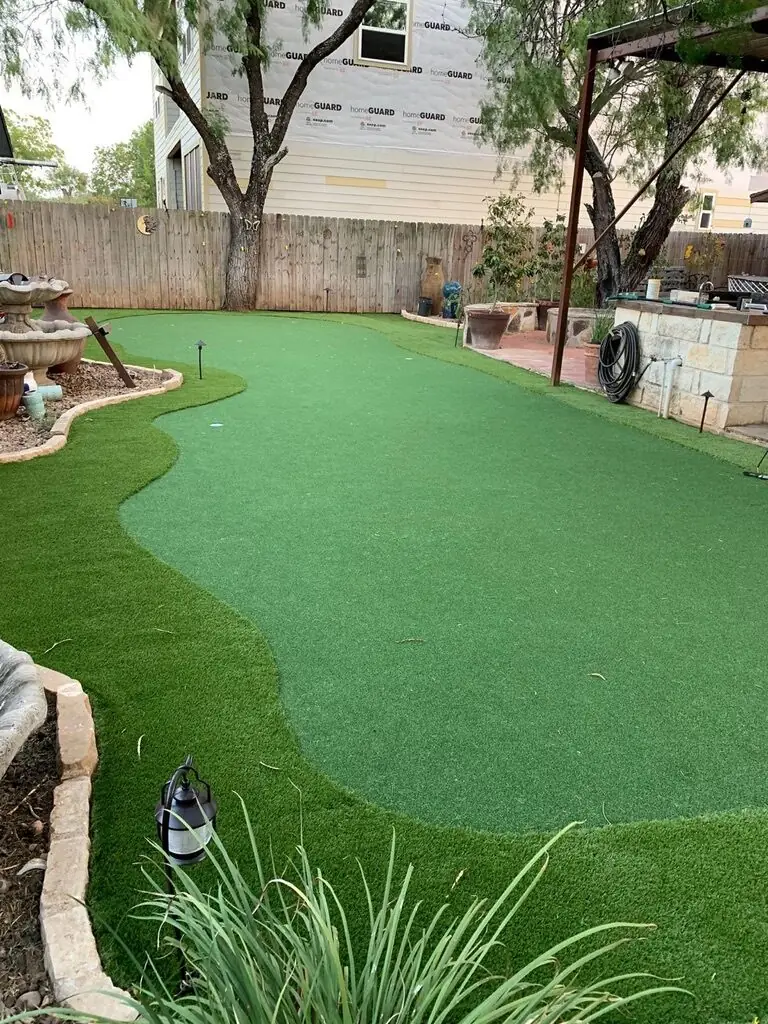 Curved putting green and turf backyard